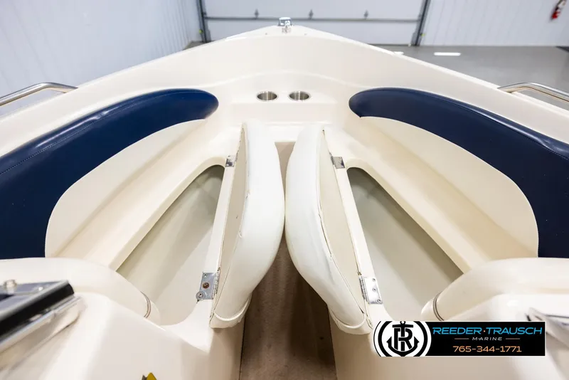 Slide: The Image of 2002 Rinker 180 boat interior with blue and white seating, Reeder-Trausch Marine logo visible. - 15