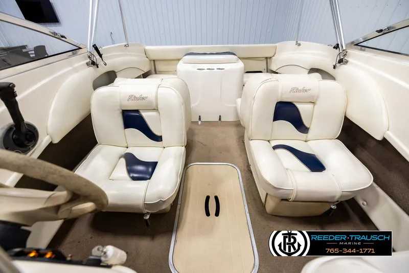 Slide: The Image of Interior of a 2002 Rinker 180 boat with white and blue seating. - 17