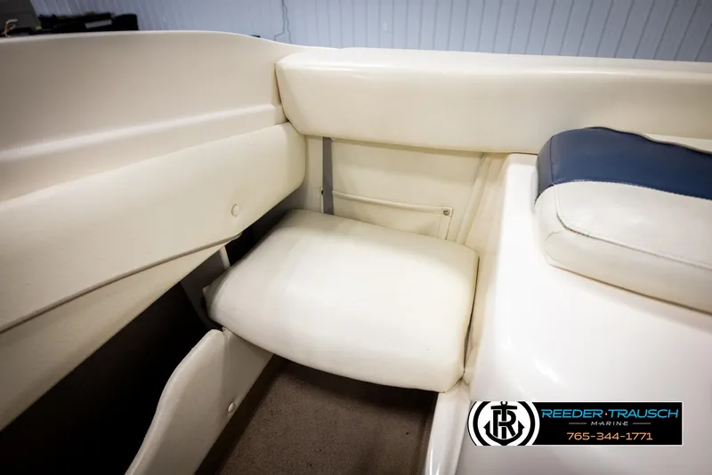 Slide: The Image of 2002 Rinker 180 boat interior with white seating and blue accents. - 19