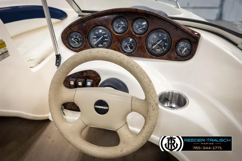Slide: The Image of 2002 Rinker 180 boat dashboard with gauges and steering wheel, Reeder-Trausch Marine logo visible. - 21