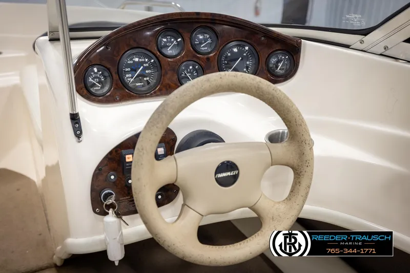 Slide: The Image of 2002 Rinker 180 boat dashboard with steering wheel and instrument panel. - 22