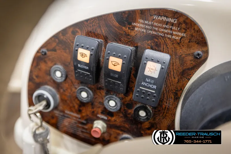 Slide: The Image of Control panel of a 2002 Rinker 180 boat with switches and warning label. - 24