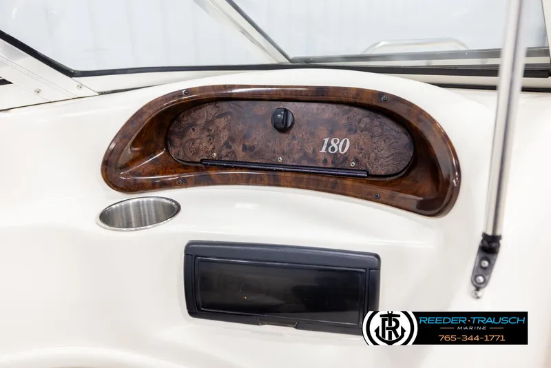 Slide: The Image of Dashboard of a 2002 Rinker 180 boat with wood trim and cup holder. - 29