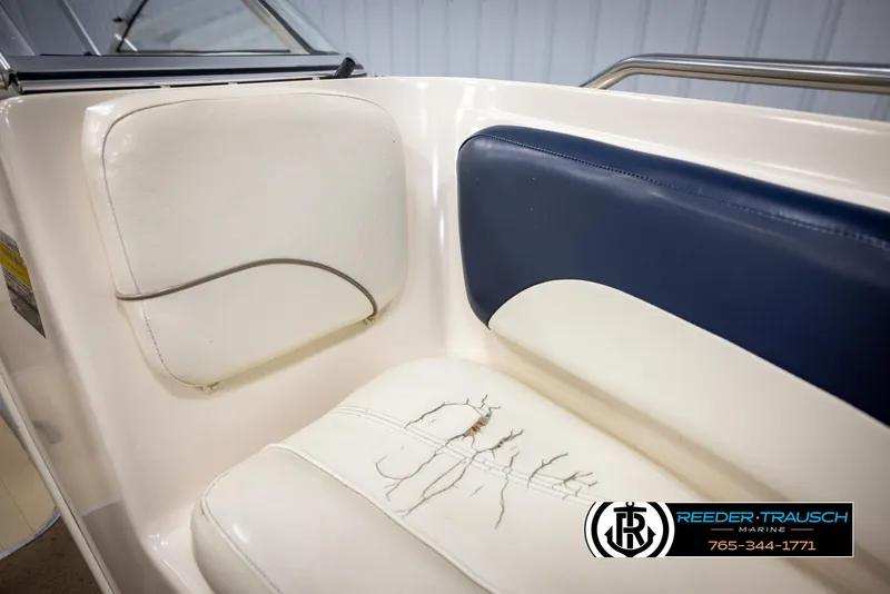Slide: The Image of 2002 Rinker 180 boat interior with worn white and blue seating. - 33