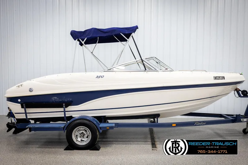 Slide: The Image of 2002 Rinker 180 boat on trailer with blue canopy in showroom. - 4