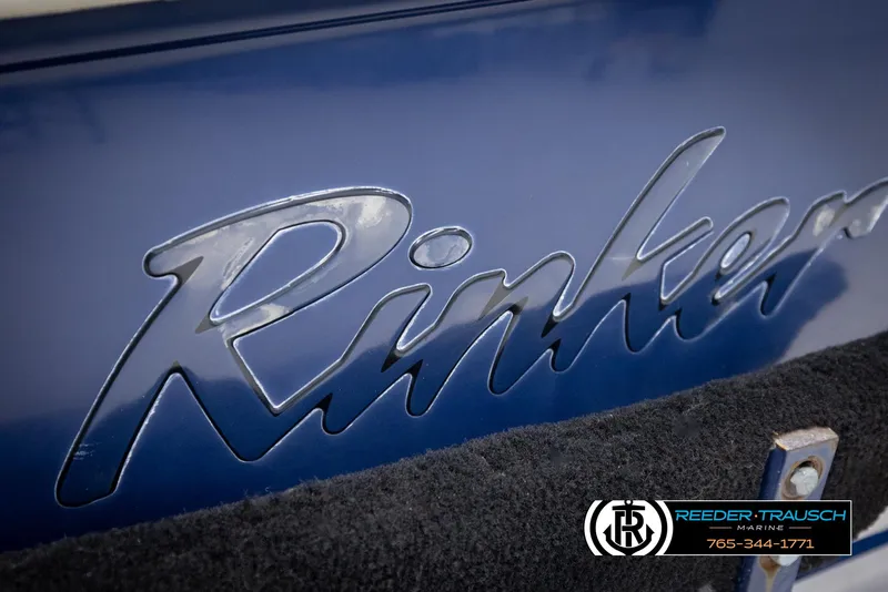 Slide: The Image of Close-up of 2002 Rinker 180 boat logo on blue surface. - 42