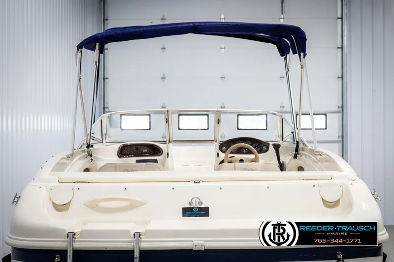 Slide: The Image of 2002 Rinker 180 boat with blue canopy in a garage setting. - 6