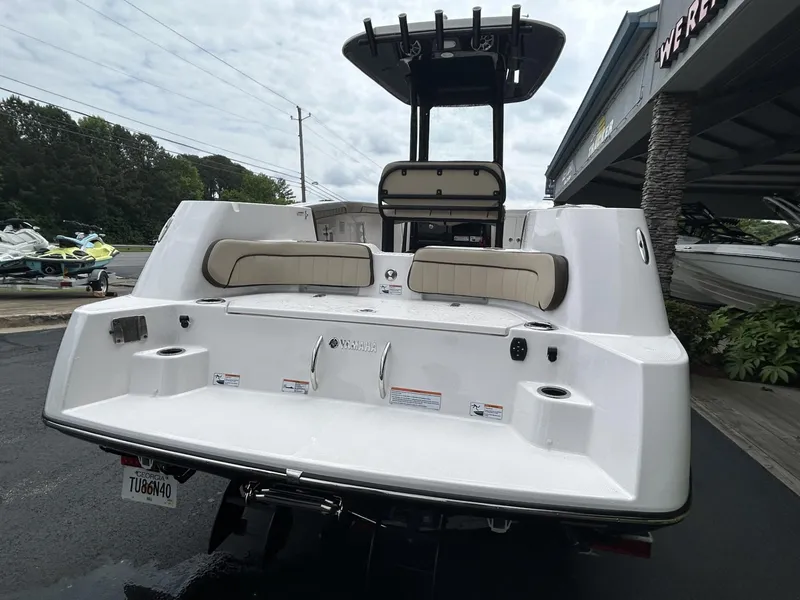 Slide: The Image of 2023 Yamaha Boats 255 FSH Sport E, rear view, white exterior, docked at marina. - 3