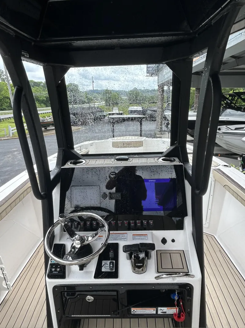 Slide: The Image of 2023 Yamaha Boats 255 FSH Sport E dashboard with steering wheel and controls. - 4