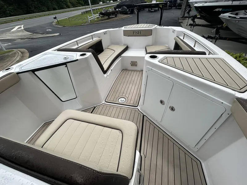 Slide: The Image of 2023 Yamaha Boats 255 FSH Sport E interior with cushioned seating and storage compartments. - 7