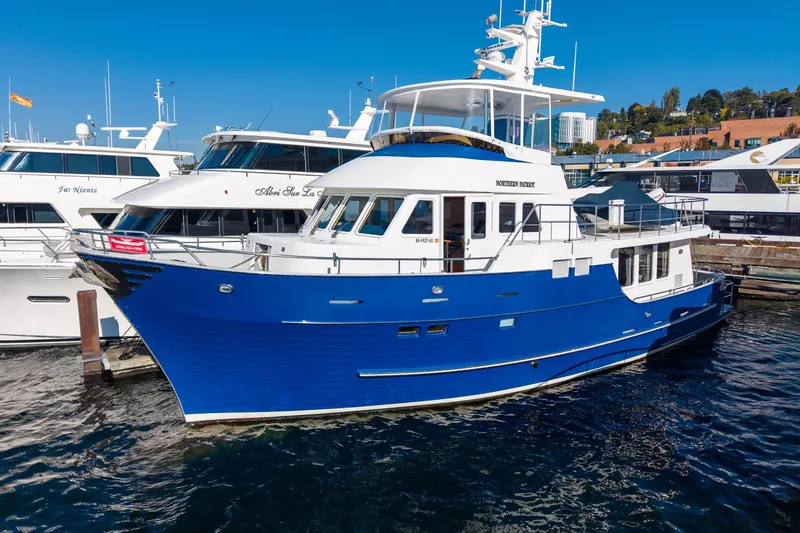 The Image of 1998 Northern Marine Trawler, blue and white, docked at marina under clear blue sky. - 0