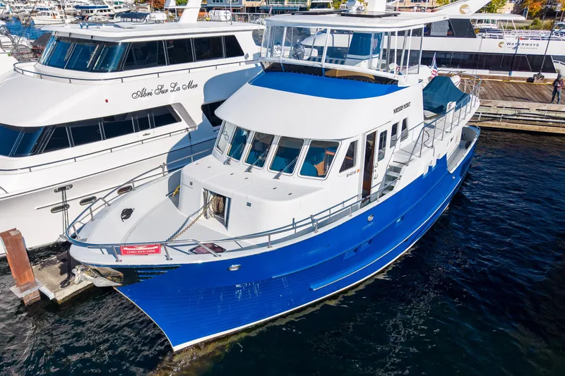 Slide: The Image of 1998 Northern Marine Trawler docked, featuring a blue and white exterior. - 1