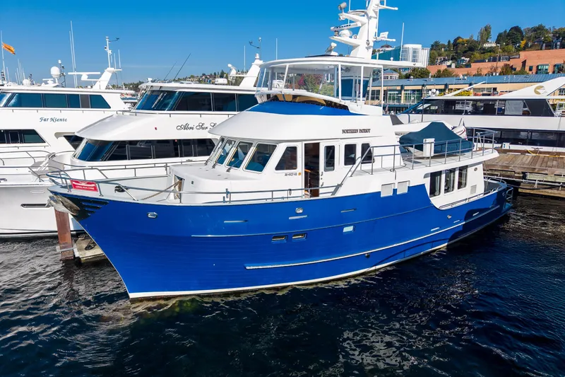 Slide: The Image of Blue 1998 Northern Marine Trawler docked at marina, surrounded by other yachts. - 2
