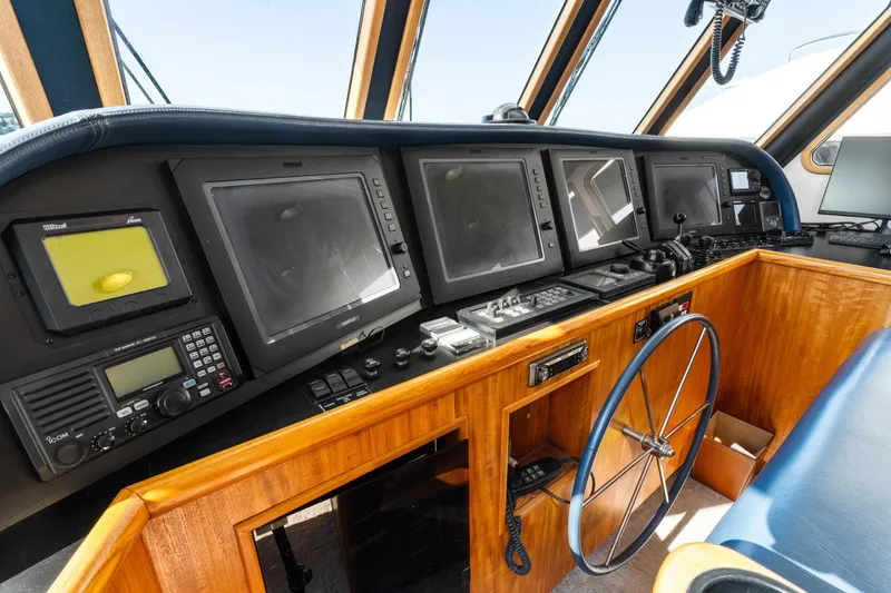 Slide: The Image of 1998 Northern Marine Trawler helm with navigation screens and wooden steering wheel. - 26