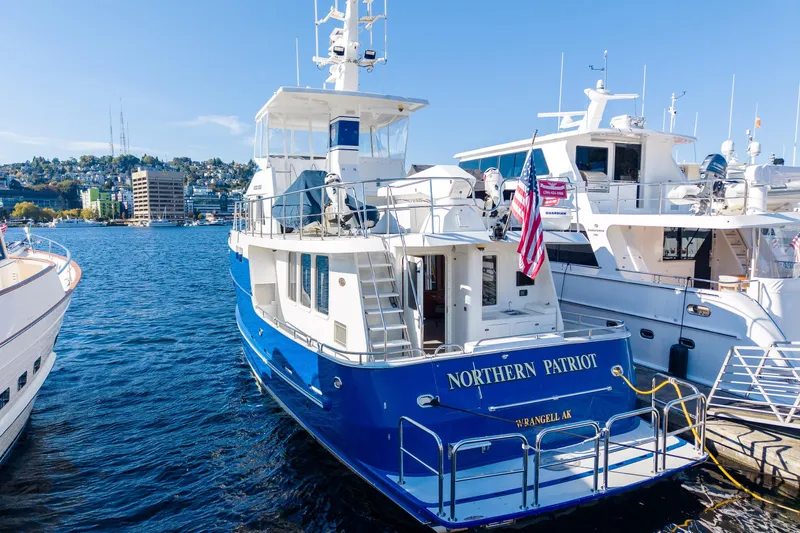 Slide: The Image of 1998 Northern Marine Trawler "Northern Patriot" docked, displaying American flag, sunny waterfront scene. - 3