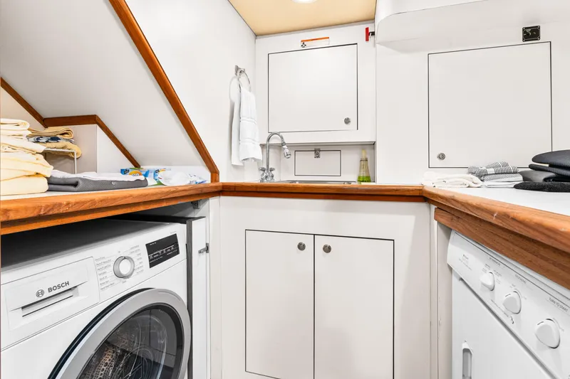 Slide: The Image of Laundry area on 1998 Northern Marine Trawler with Bosch washer, wooden countertops, and storage cabinets. - 34