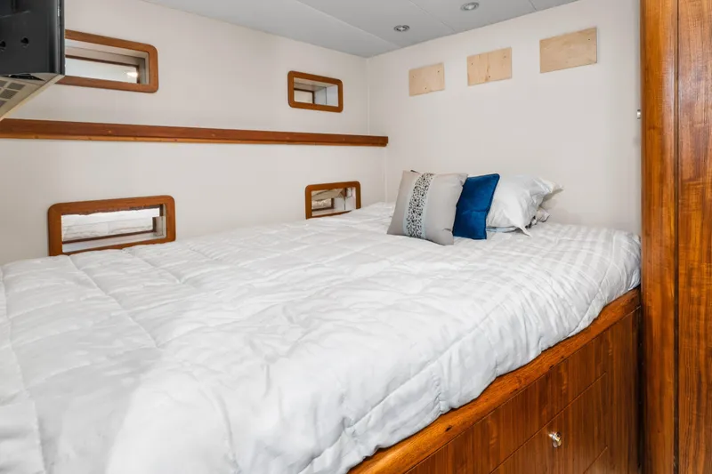 Slide: The Image of Cozy bedroom interior in 1998 Northern Marine Trawler with wooden accents and plush bedding. - 37