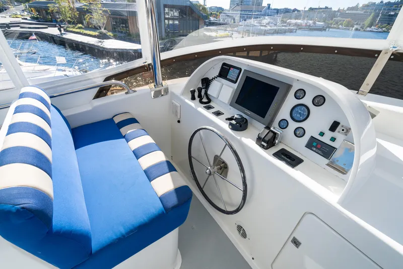 Slide: The Image of Helm of 1998 Northern Marine Trawler with blue-striped seating and navigation controls. - 49