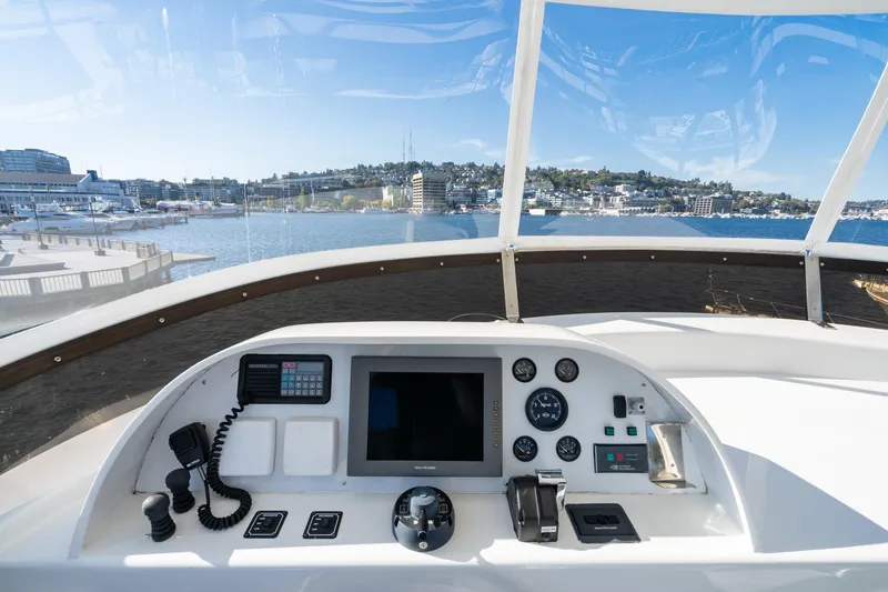 Slide: The Image of Cockpit view of a 1998 Northern Marine Trawler overlooking a marina and cityscape. - 50