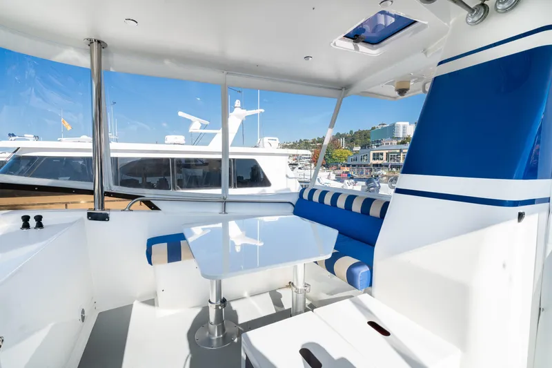 Slide: The Image of 1998 Northern Marine Trawler interior with blue and white seating, docked at marina. - 51