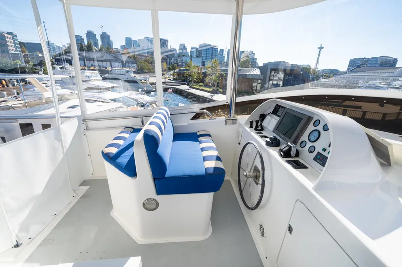 Slide: The Image of 1998 Northern Marine Trawler helm with blue-striped seating and cityscape view. - 53