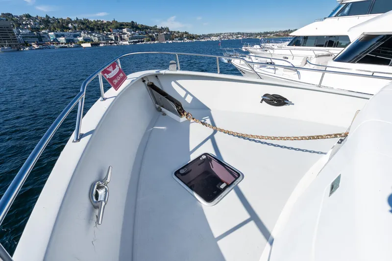 Slide: The Image of 1998 Northern Marine Trawler bow with anchor chain, docked in a marina under clear skies. - 55