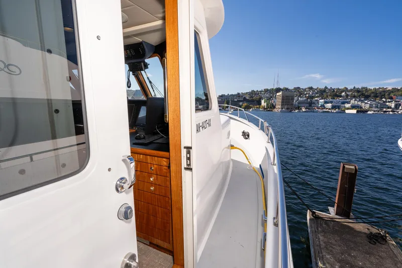 Slide: The Image of 1998 Northern Marine Trawler docked, showing open cabin door and scenic waterfront view. - 59