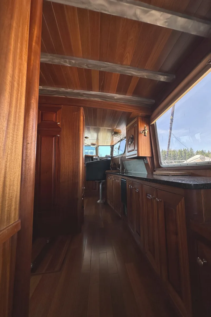 Slide: The Image of Interior of 2002 Carlson Marine Trawler with wooden paneling and helm station. - 12