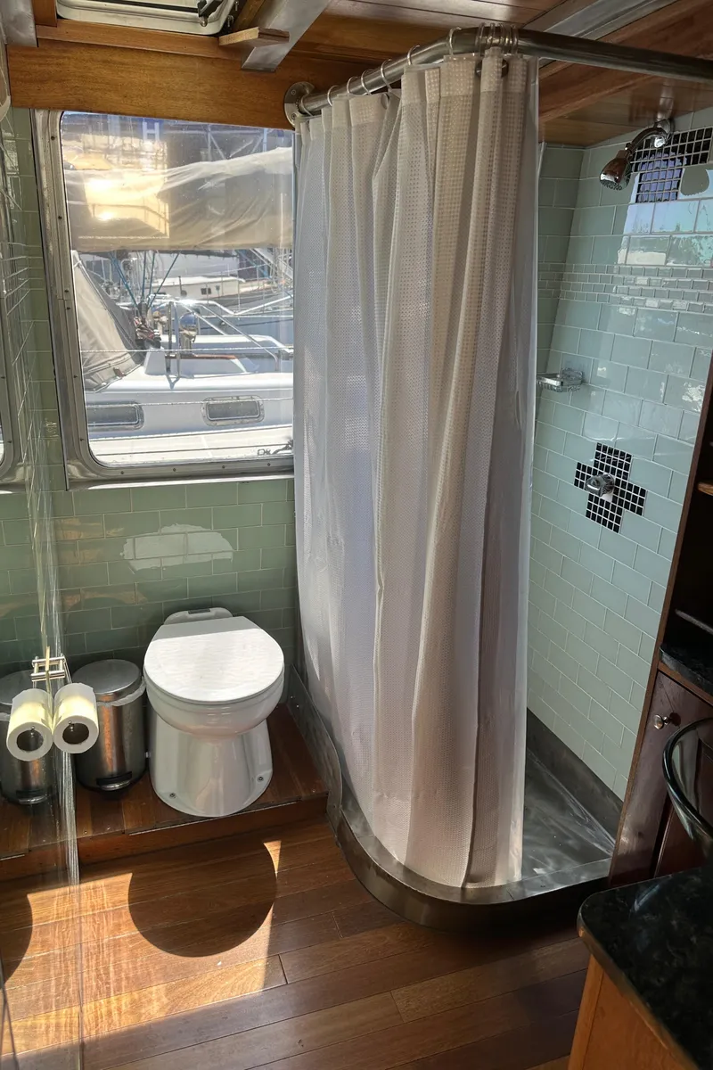 Slide: The Image of Bathroom interior of 2002 Carlson Marine Trawler with shower and toilet, featuring wood flooring. - 14