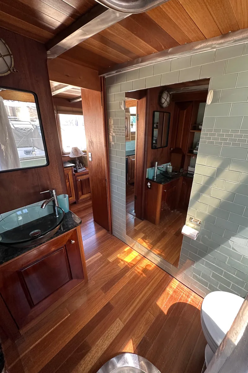 Slide: The Image of Interior of 2002 Carlson Marine Trawler with wood and tile finishes, featuring a modern bathroom. - 16