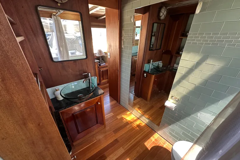 Slide: The Image of Luxurious bathroom interior on 2002 Carlson Marine Trawler with wood accents and glass sink. - 17