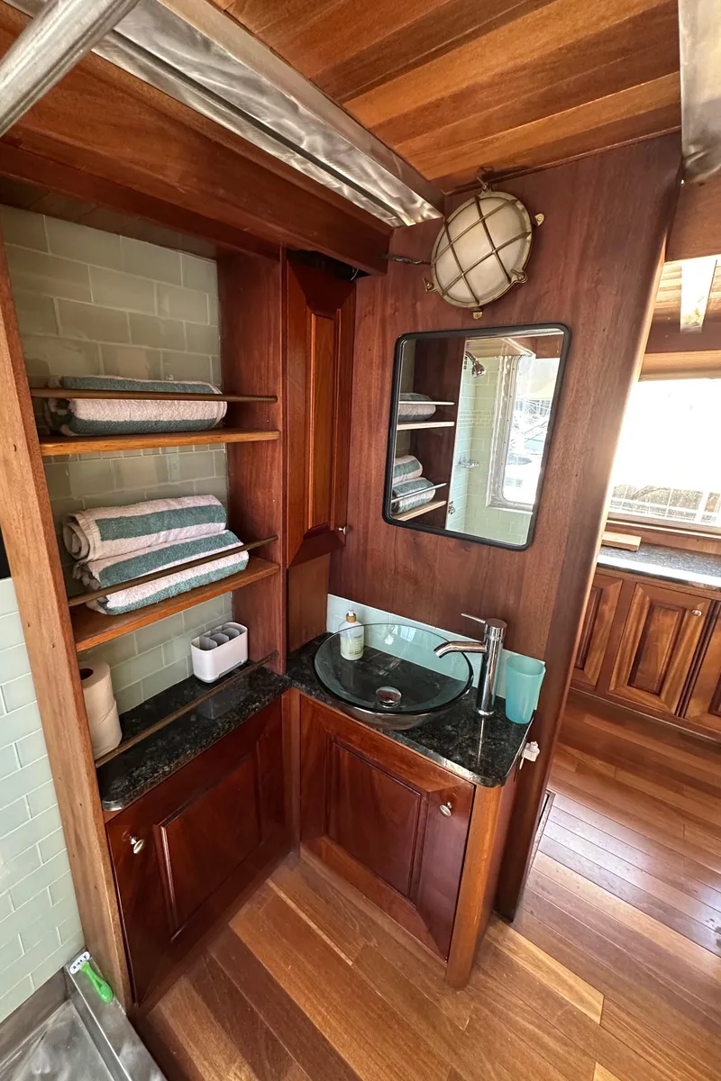 Slide: The Image of Cozy wooden bathroom in 2002 Carlson Marine Trawler with sink, mirror, and shelves. - 18