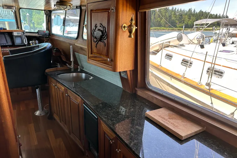Slide: The Image of Interior of 2002 Carlson Marine Trawler with wooden cabinetry and granite countertop. - 19