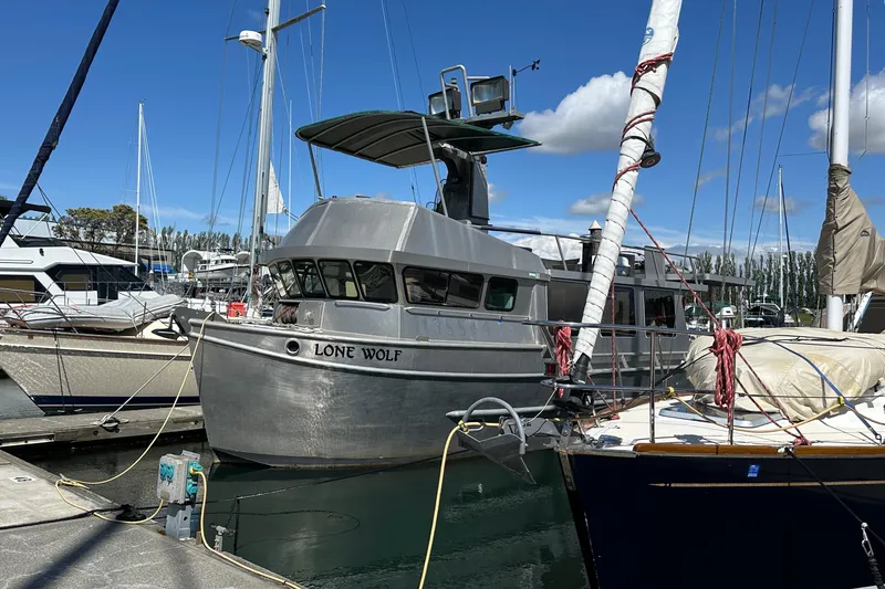 Slide: The Image of Custom 2002 Carlson Marine Trawler "Lone Wolf" docked at marina under blue sky. - 2