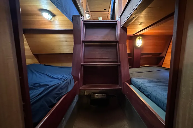 Slide: The Image of Cozy wooden cabin interior of 2002 Carlson Marine Trawler with twin beds and warm lighting. - 24
