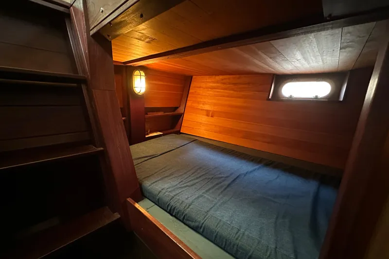 Slide: The Image of Cozy wooden cabin interior of 2002 Carlson Marine Trawler with bed and porthole window. - 25