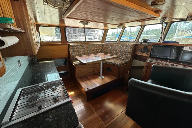 Slide: The Image of Interior of 2002 Carlson Marine Trawler with kitchen, seating, and navigation equipment. - 28