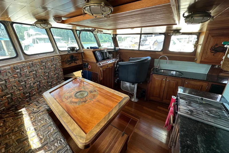 Slide: The Image of Interior of 2002 Carlson Marine Trawler with wood finish, seating, and navigation area. - 29
