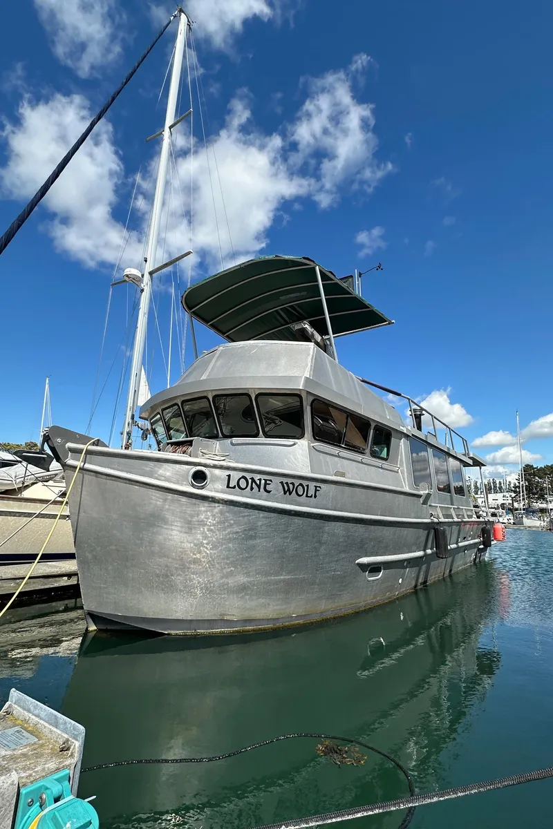 Slide: The Image of Custom 2002 Carlson Marine Trawler "Lone Wolf" docked at marina under blue sky. - 3