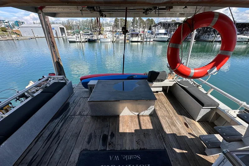 Slide: The Image of Deck of 2002 Carlson Marine Trawler with seating, life preserver, and marina view. - 31
