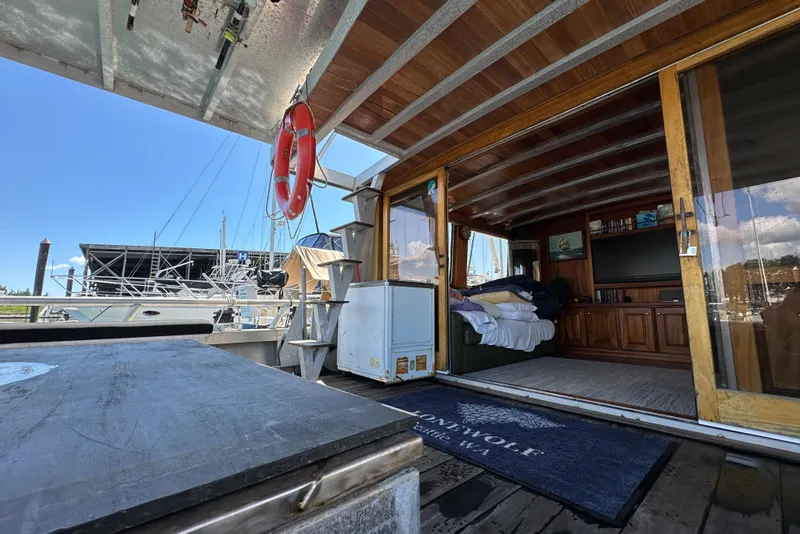 Slide: The Image of Custom 2002 Carlson Marine Trawler with open cabin, wooden interior, and marina view. - 33