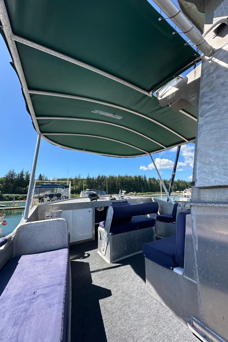 Slide: The Image of Custom 2002 Carlson Marine Trawler interior with canopy, seating, and scenic marina view. - 36