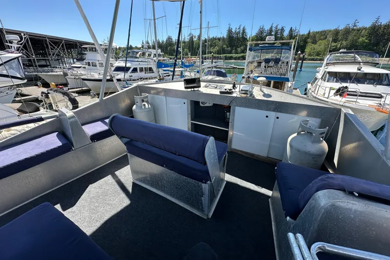 Slide: The Image of Custom 2002 Carlson Marine Trawler with blue seating, docked among other boats in a marina. - 37