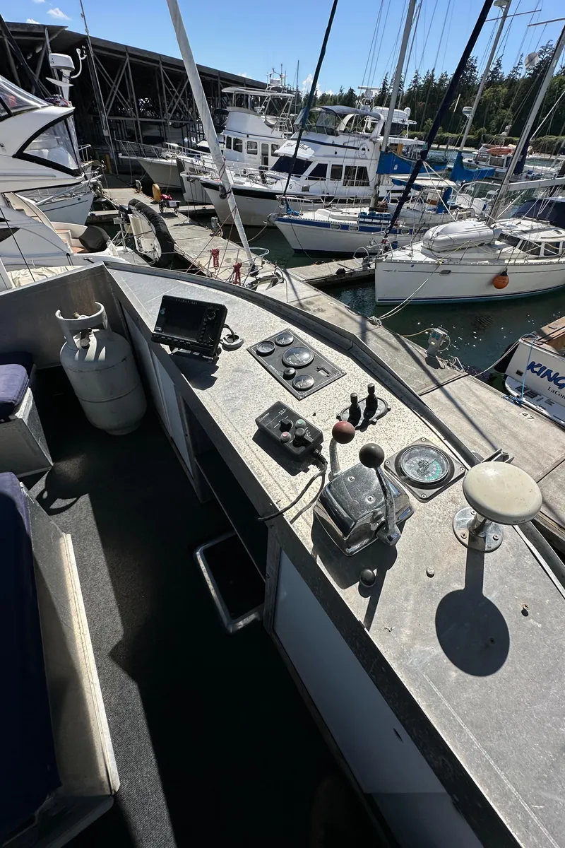 Slide: The Image of Cockpit of 2002 Carlson Marine Trawler with navigation controls, docked at marina. - 38