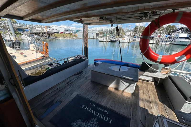 Slide: The Image of Custom 2002 Carlson Marine Trawler docked, featuring spacious deck with seating and life preserver. - 42