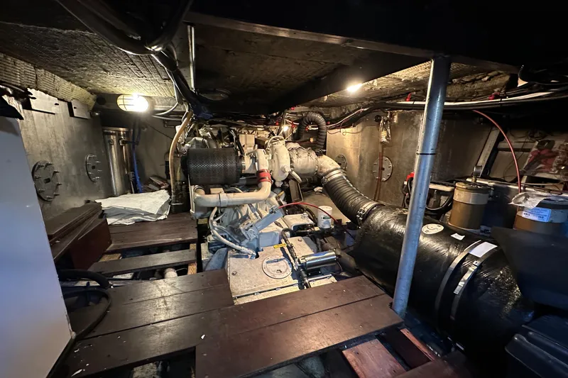 Slide: The Image of Engine room of a 2002 Carlson Marine Trawler, showcasing mechanical components and piping. - 43