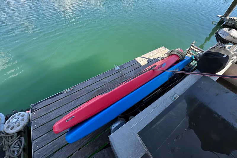 Slide: The Image of Dockside view with red and blue kayaks beside a 2002 Carlson Marine Trawler. - 44
