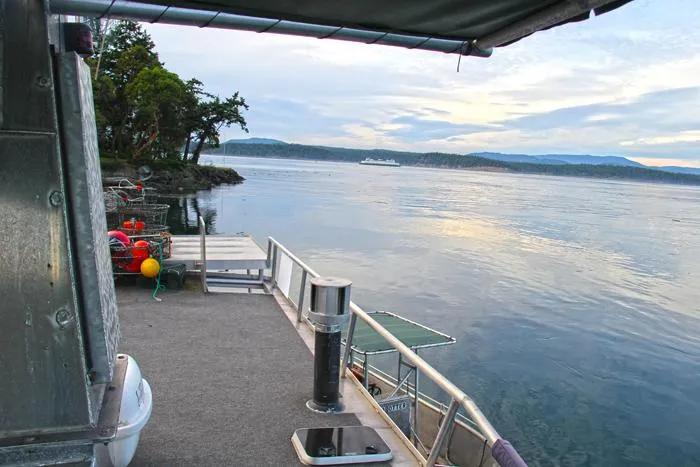 Slide: The Image of Custom Carlson Marine Trawler, 2002, docked by scenic shoreline with calm waters and distant ferry. - 49