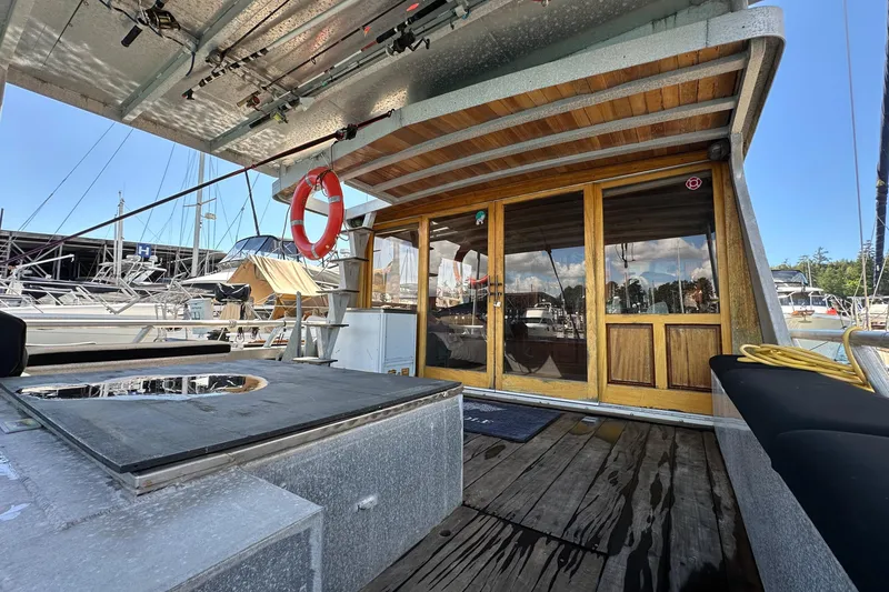 Slide: The Image of Custom 2002 Carlson Marine Trawler with wooden doors, docked at marina, featuring outdoor seating and equipment. - 5