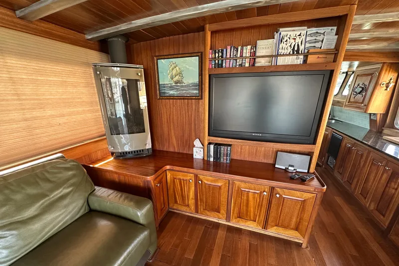 Slide: The Image of Luxurious 2002 Carlson Marine Trawler interior with wood paneling, TV, and cozy seating area. - 9